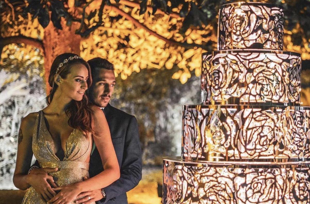 Illuminazione per matrimonio con torta luminosa con accanto una coppia di sposi