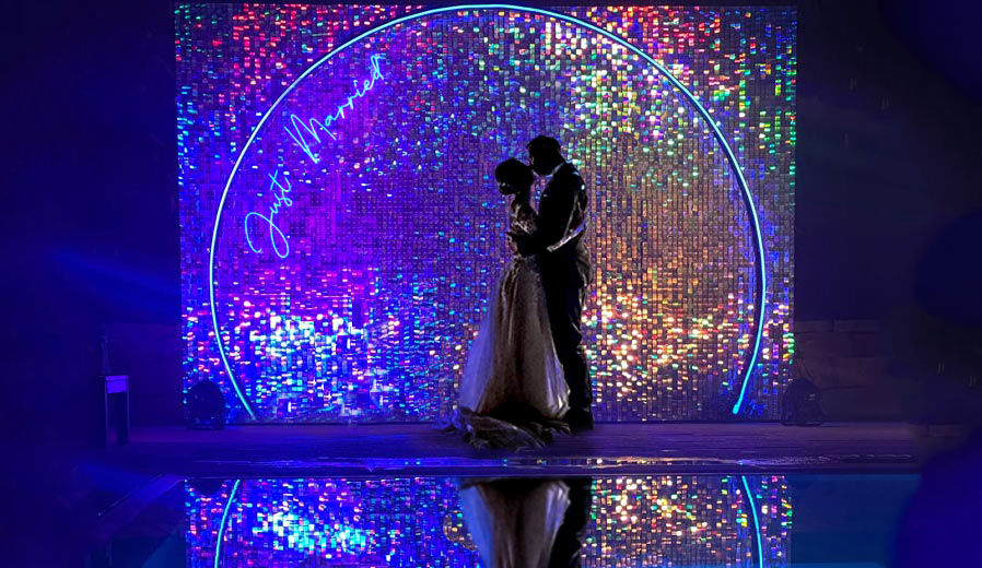 Coppia di sposi in posa su photobooth matrimonio con shimmer wall