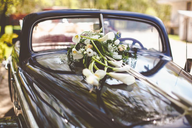 Mazzo di fiori sopra il cofano di una macchina vintage in occasione di un anniversario di nozze